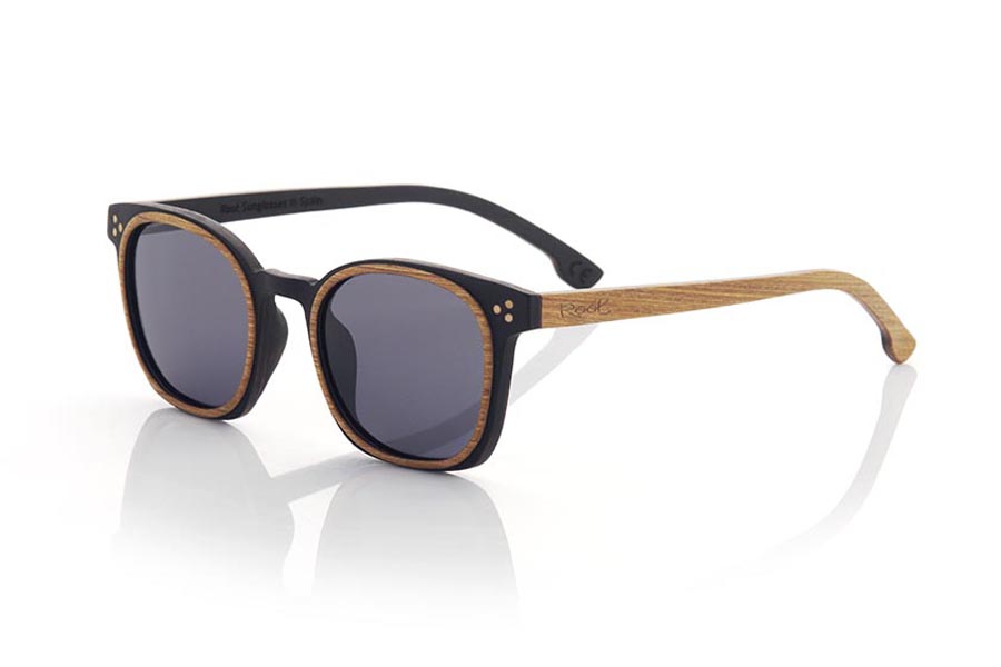 Wood eyewear of Walnut modelo DAIVI. DAIVI wooden sunglasses are a variation of our GUSTAV model. In this model, the frame spectacularly combines walnut and oak wood in different reliefs, while the temples are made of oak on the outside and walnut on the inside. This unisex model combines the rounded relief with a squarer frame to give an elegant and sophisticated appearance. The glasses are available in two solid lens colors, brown and grey. With the DAIVI, you will have a fresh and modern look while enjoying the unique quality and style that only wooden glasses can offer. Front Measurement: 141X47mm Caliber:48 | Root Sunglasses® 